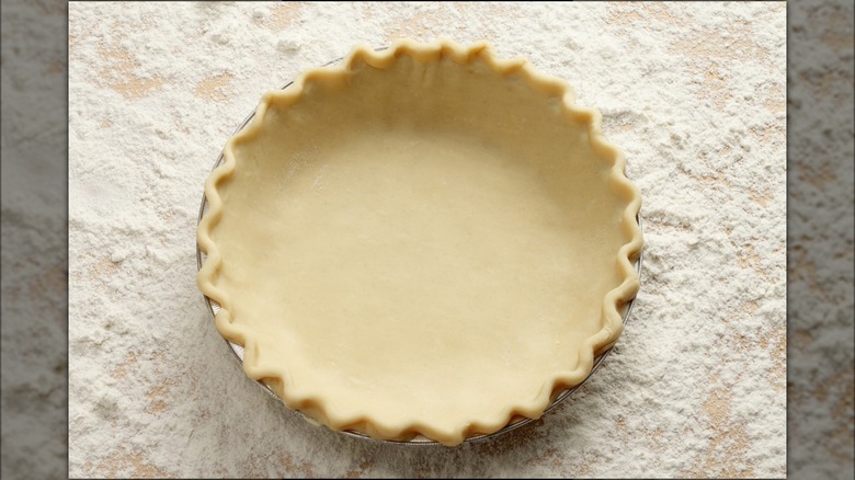 raw pie crust crimped in tin