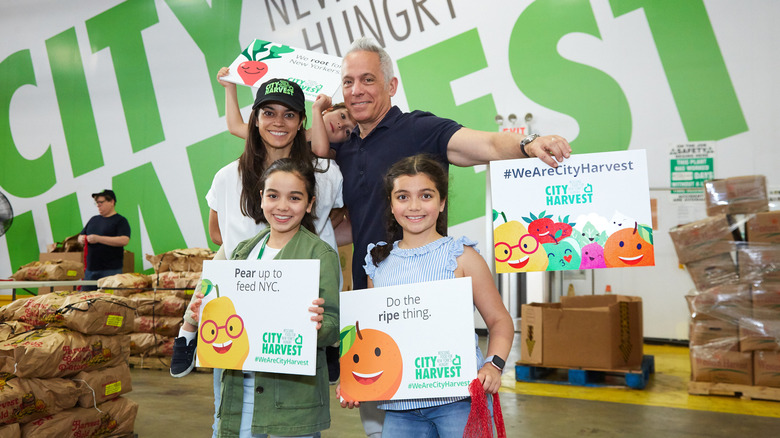 Margaret Anne Williams, Geoffrey Zakarian, and family holding City Harvest signs