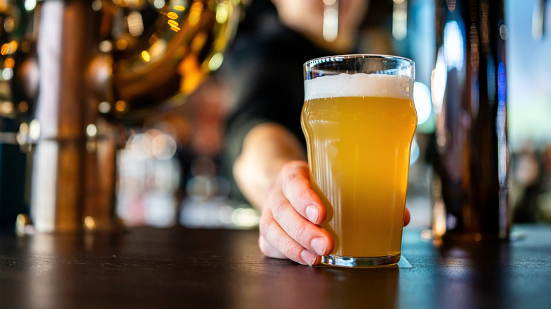 Batender serving a glass of American draft beer