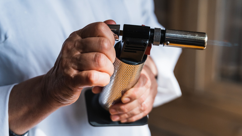 Chef holding kitchen torch