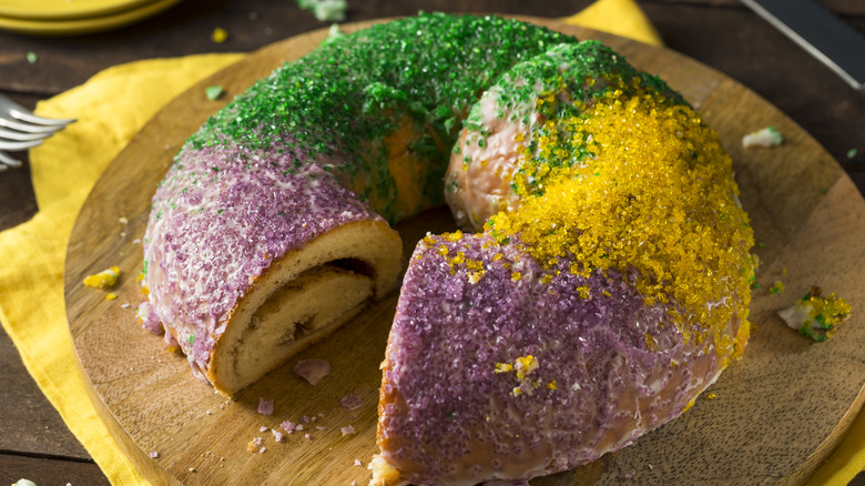 mardi gras king cake on a rustic wood cutting board