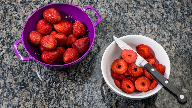 bowls of strawberries with knife