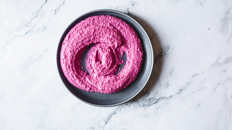 pink beet hummus on black plate