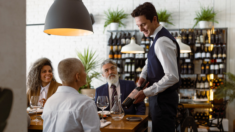 waiter presenting wine to table