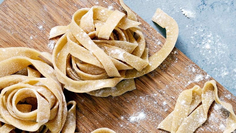 Fresh pasta noodles on wooden board