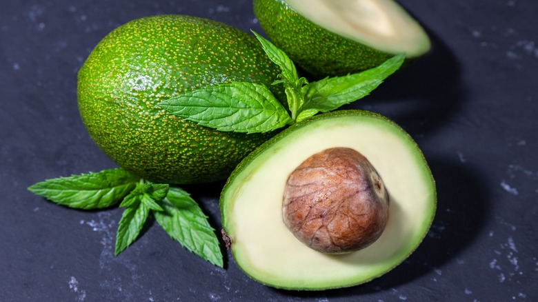 A sliced avacado with a pit inside