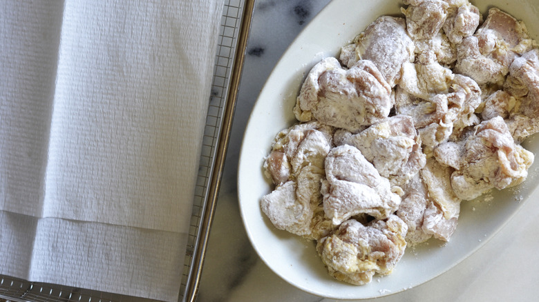 floured chicken pieces on plate