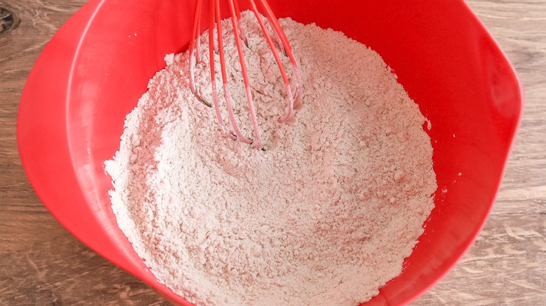 dry cake ingredients in a bowl being whisked