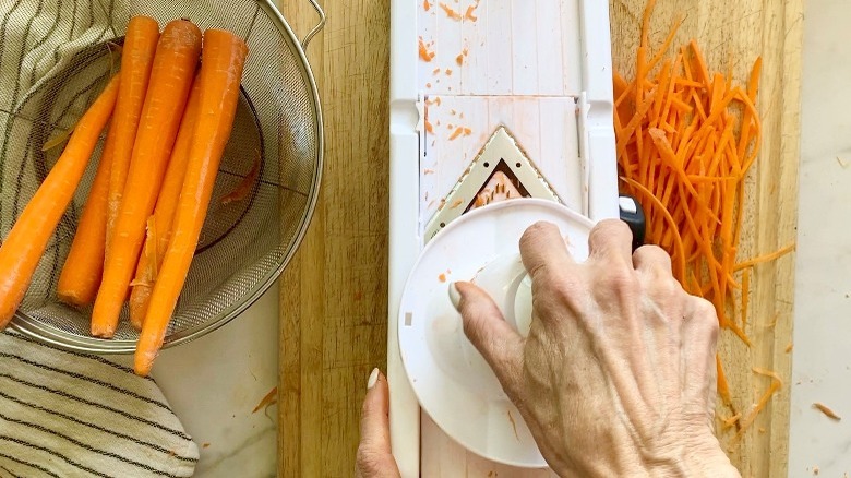 slicing the carrots with a mandolin