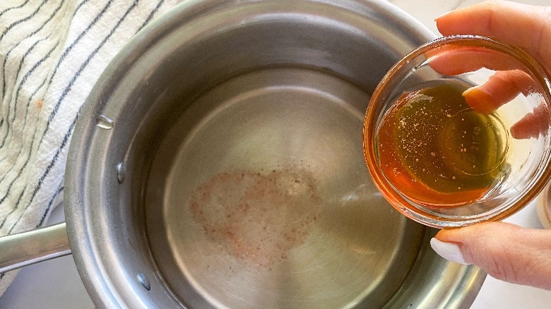 adding ingredients to a pot for the brine