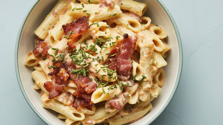 bowl of pasta topped with crispy prosciutto