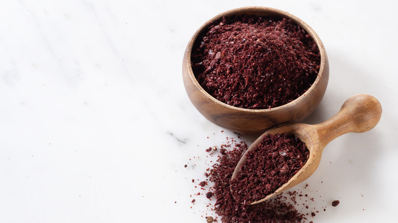 Wooden bowl and scoop of powdered sumac