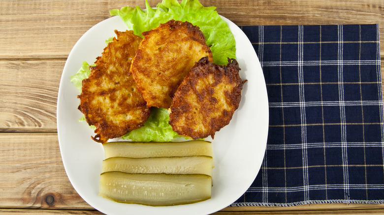 potaot pancakes and dill spears on a plate