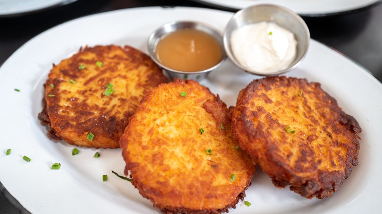 latkes on a plate with applesauce and sour cream