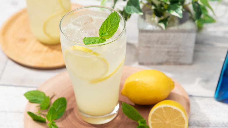 A glass of lemonade with fresh lemons