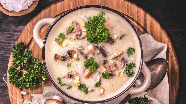 Top-down view of a bowl of mushroom soup and parsley