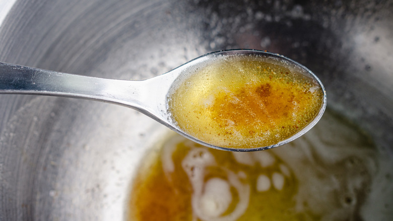 tablespoon of brown butter above a saucepan with brown butter