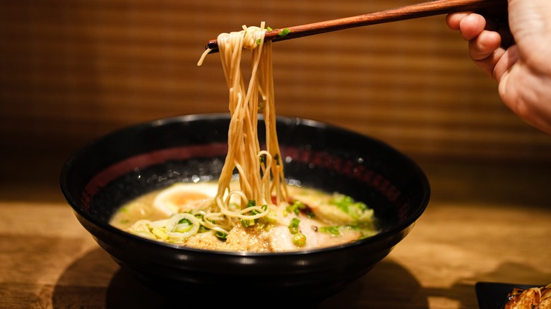 chopsticks holding ramen noodles