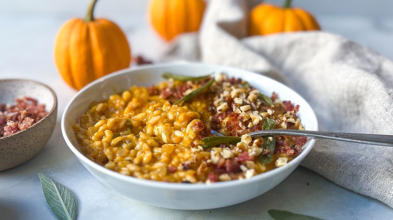 Pumpkin risotto in a bowl with pumpkins