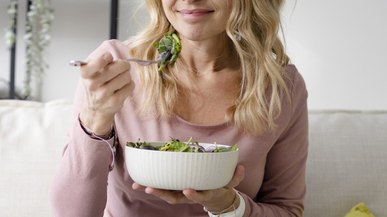 Woman eating a bowl of salad