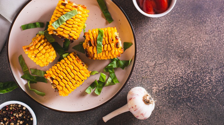 grilled corn on the cob with a garlic clove