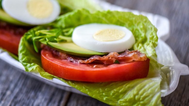 egg, bacon, tomato on lettuce leaf