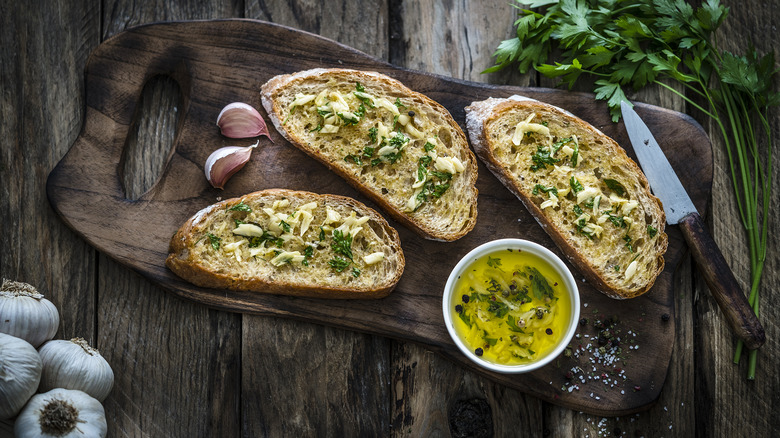 Slices of homemade garlic bread on wood board