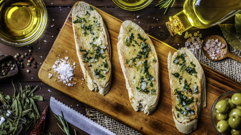 Slices of homemade garlic bread on wood board