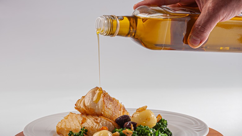 chef drizzling oil onto plate