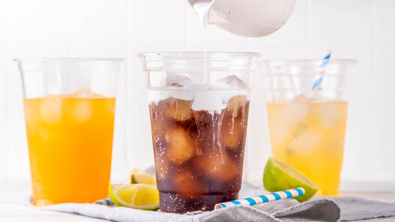 Three glasses of soda with ice, creamer