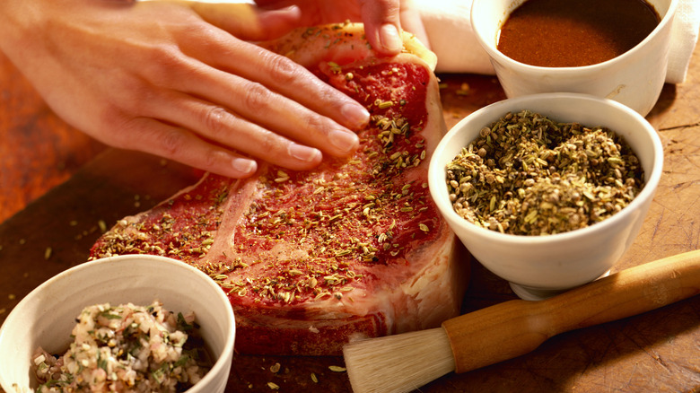 Home cook rubbing seasoning onto a steak