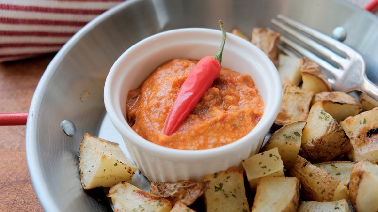 Roasted potatoes beneath a dish of mojo