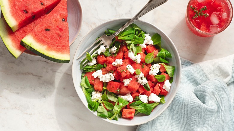 bowl of watermelon salad with fresh watermelon slices