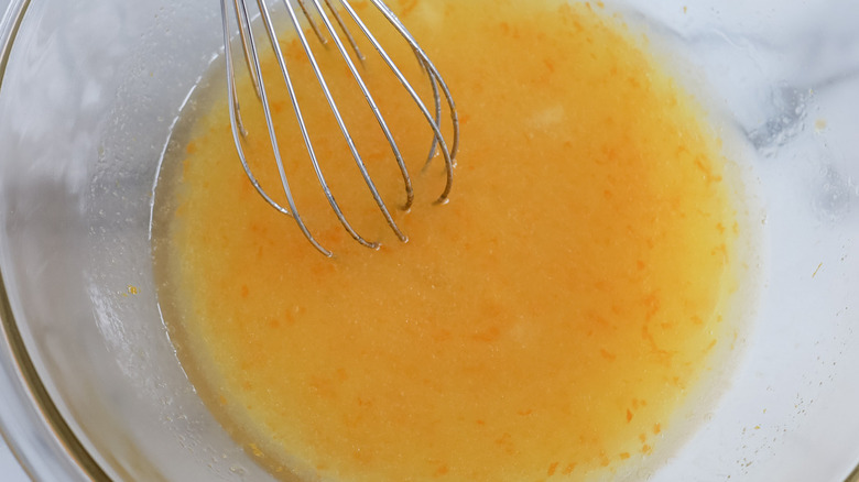 orange liquid and whisk in glass bowl