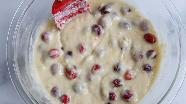 cranberry bread batter in glass bowl with rubber spatula