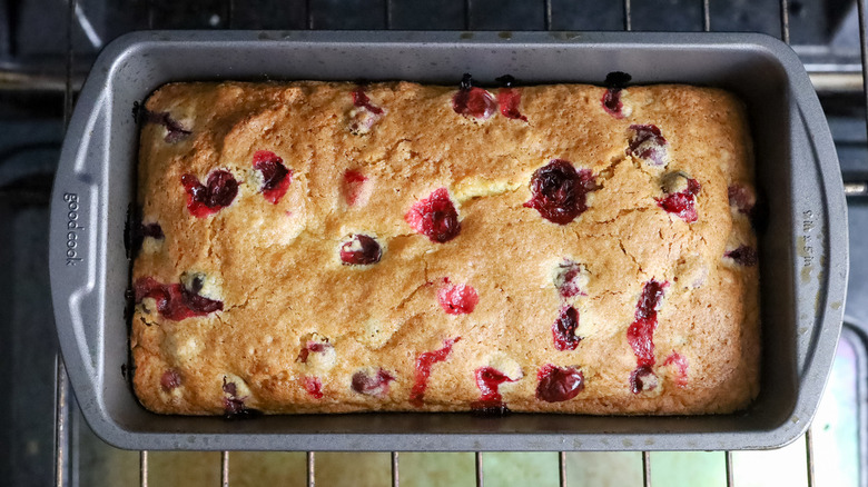 baked cranberry bread in loaf pan on oven rack