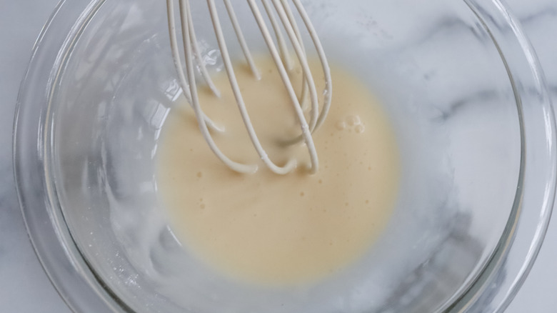 whisking eggnog glaze in bowl