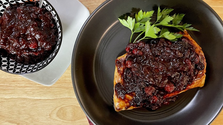 salmon with cranberry compote on black plate