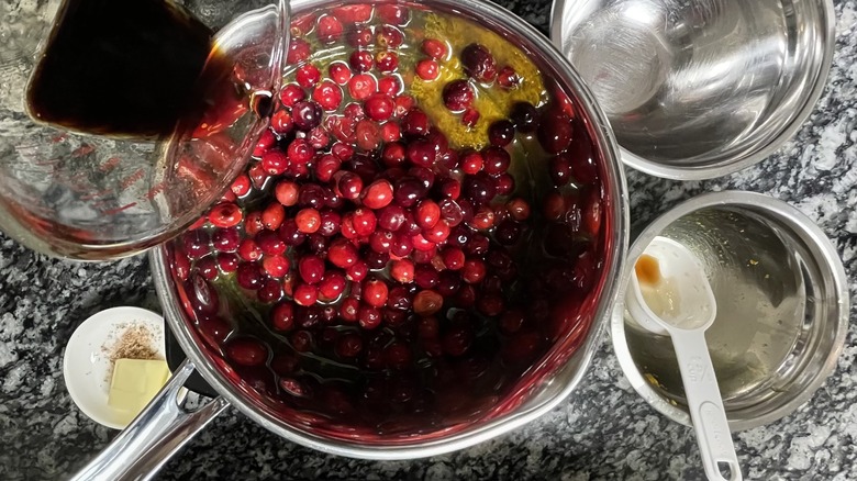 balsamic pouring into pot with cranberries