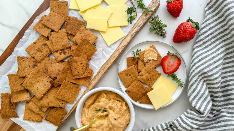 crackers with cheese, strawberries, and dip