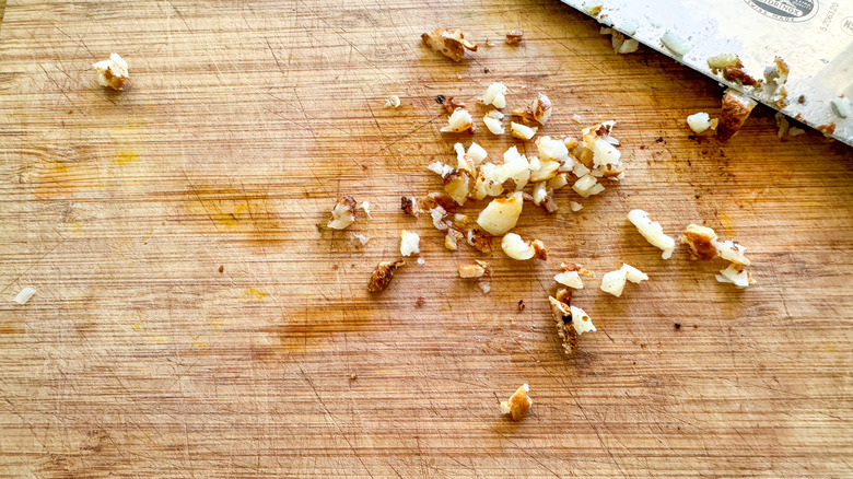 minced garlic on board with knife