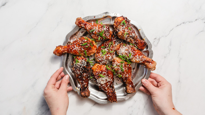 Serving platter with saucy chicken drumsticks