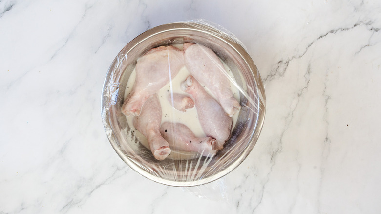 drumsticks in marinade covered in plastic wrap