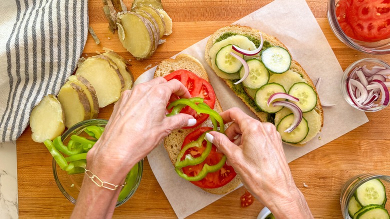 hand adding green pepper