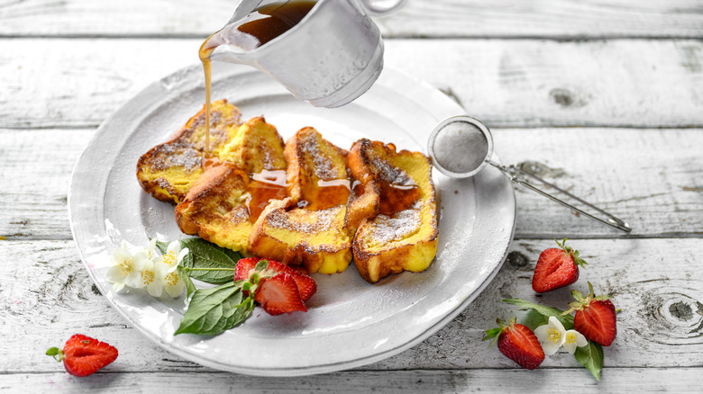 pouring syrup onto French toast