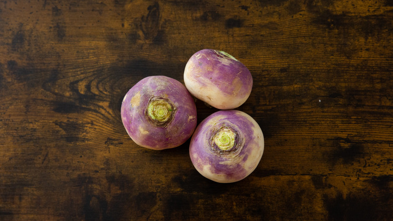 three turnips on wooden table