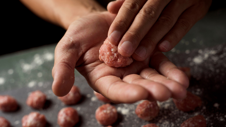 hands rolling meatballs