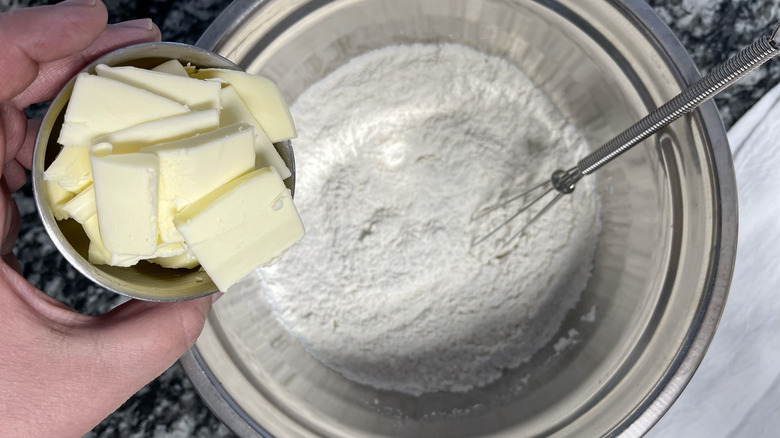 adding butter to flour in bowl