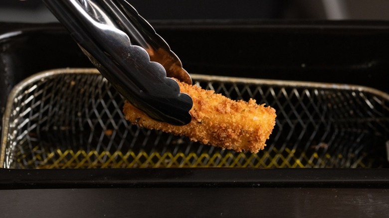 cooked mozzarella stick in tongs