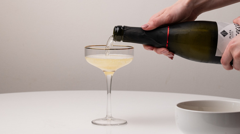 pouring Prosecco into cocktail